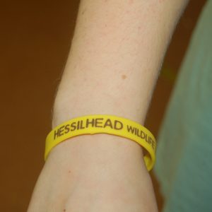 A lady wearing a Hessilhead supporter wrist band